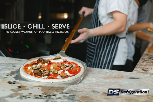 Commercial refrigerated pizza prep counter with fresh pizza toppings in a busy pizzeria kitchen.